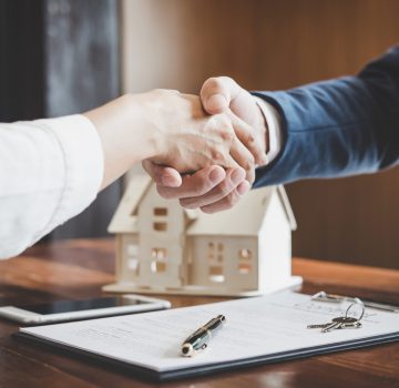 Real estate agent and customers shaking hands together celebrating finished contract after about home insurance and investment loan, handshake and successful deal.
